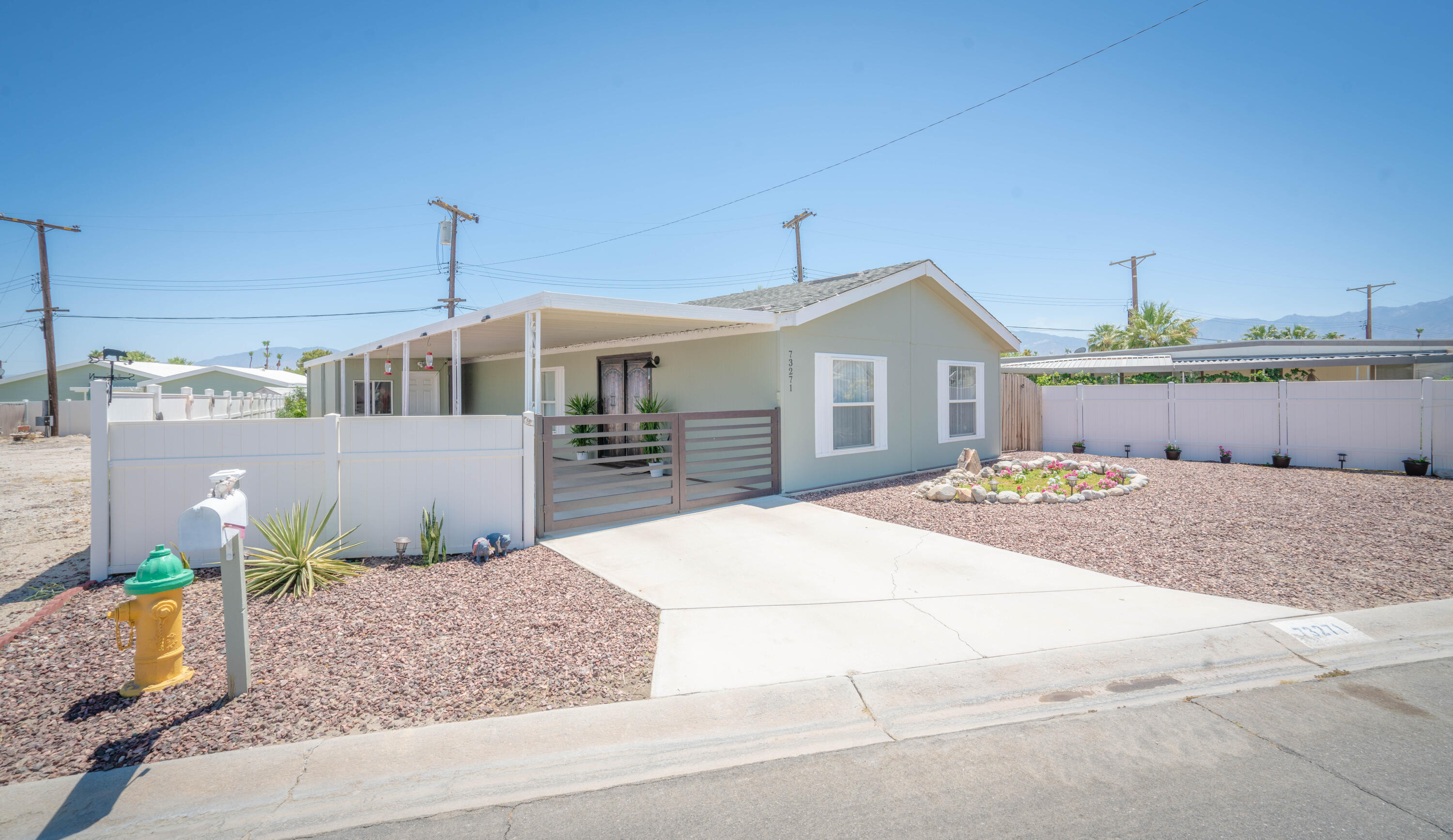 a front view of a house with a yard and potted plants