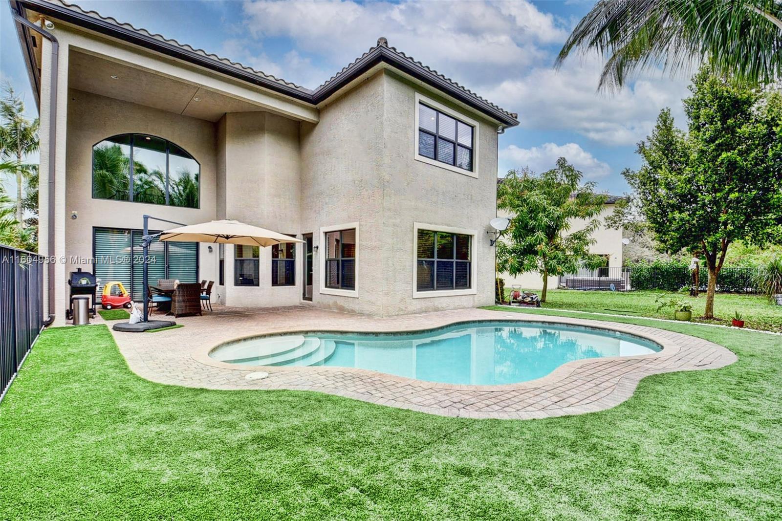 a view of a house with swimming pool and a yard