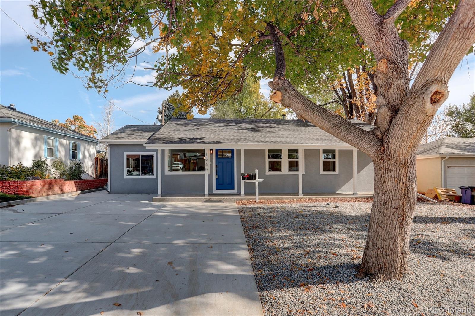 a front view of a house with a tree