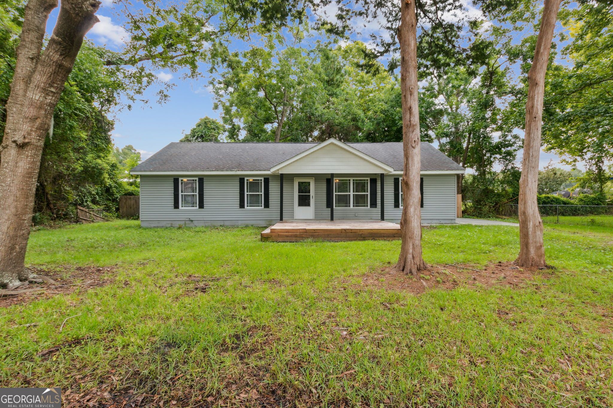 a front view of a house with yard and green space