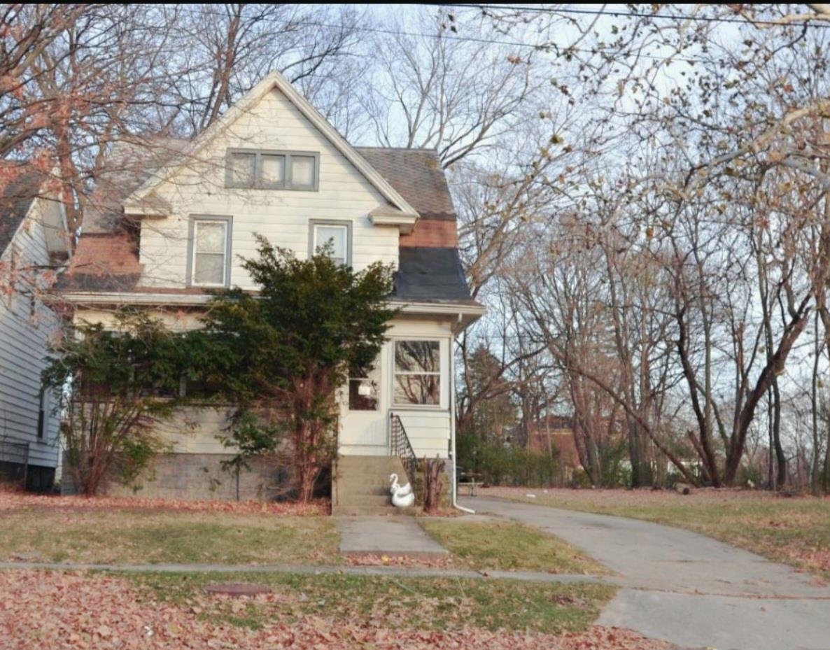 a view of a white house with a street