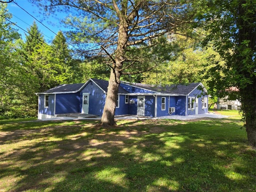 a big house with large tree in front of it