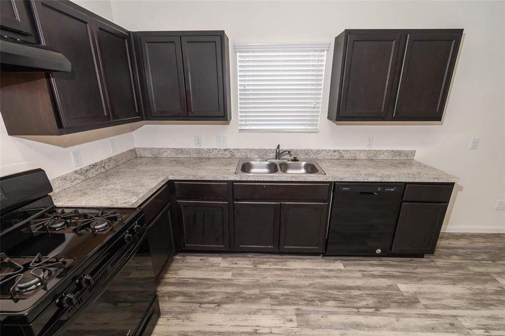 a kitchen with granite countertop a stove and a sink