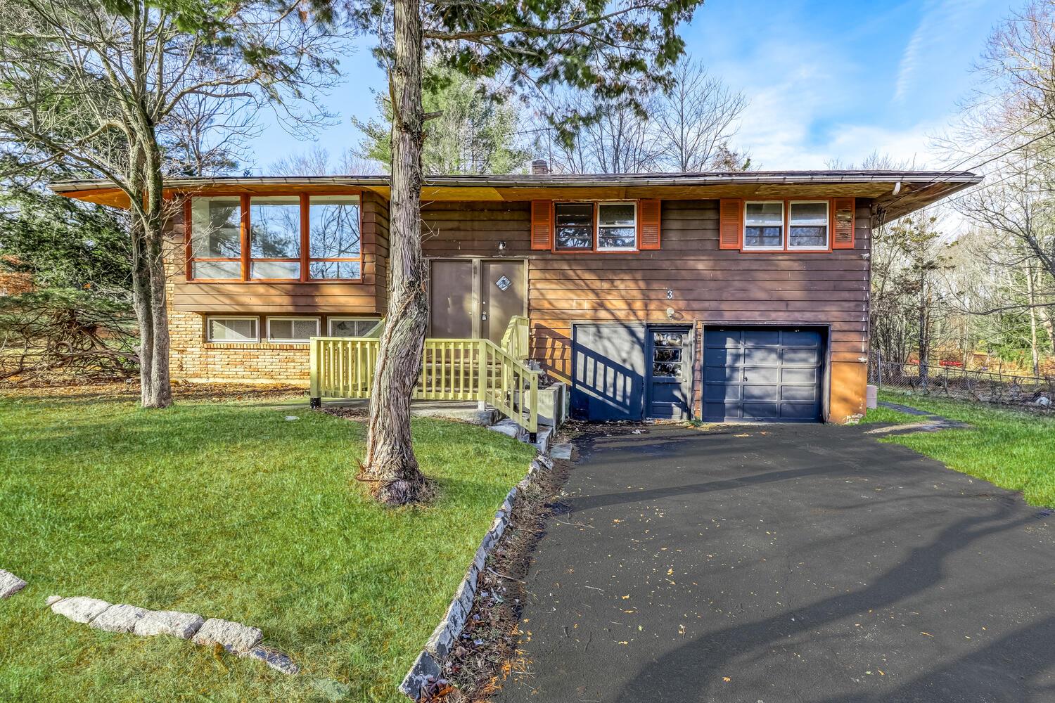 Bi-level home with a garage and a front yard