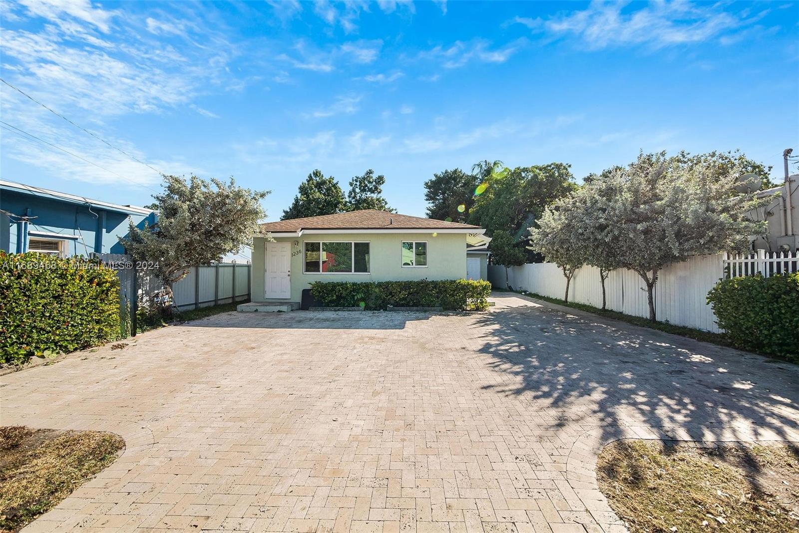 a front view of a house with a yard and trees