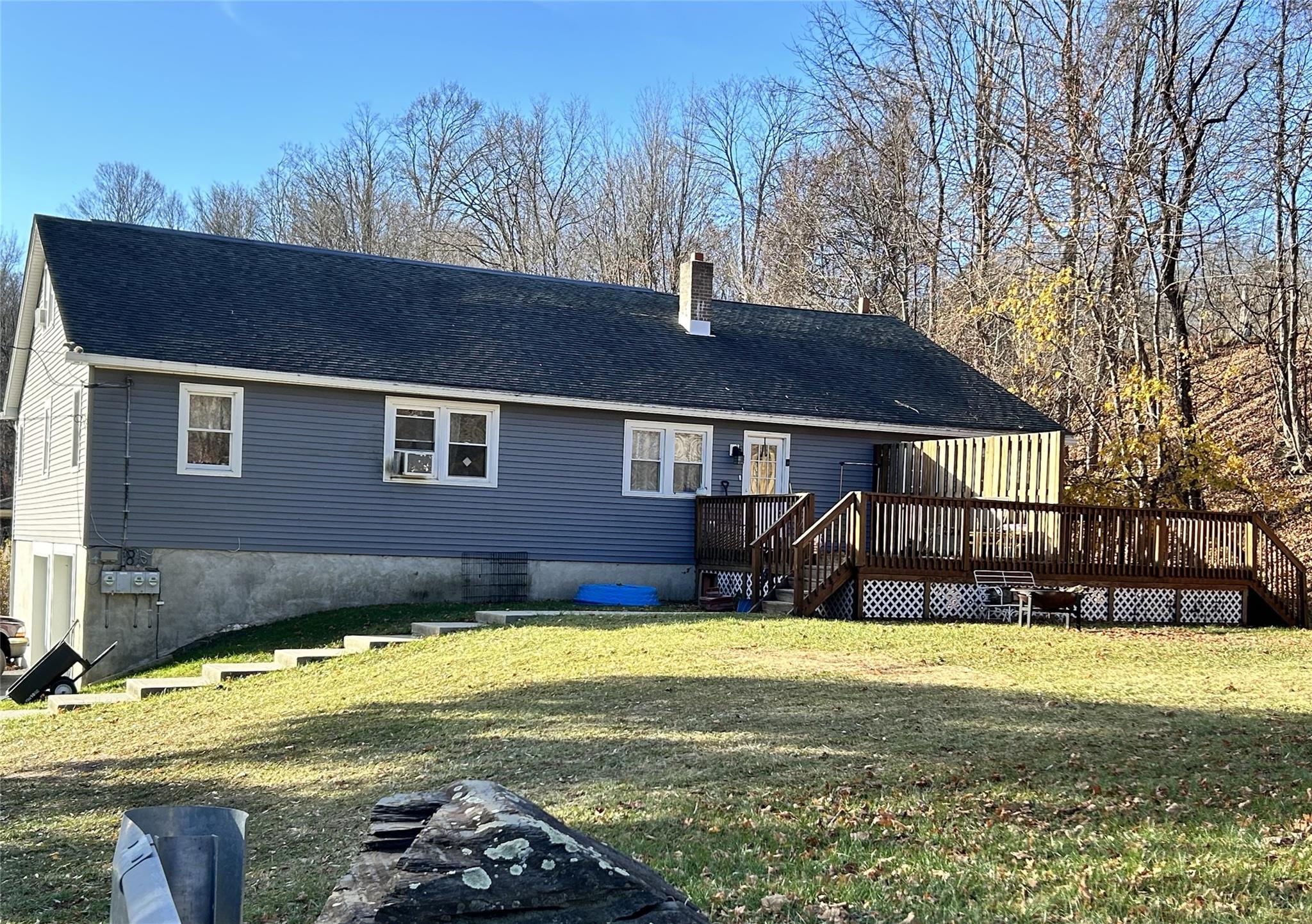 Rear view of property with a yard and a deck