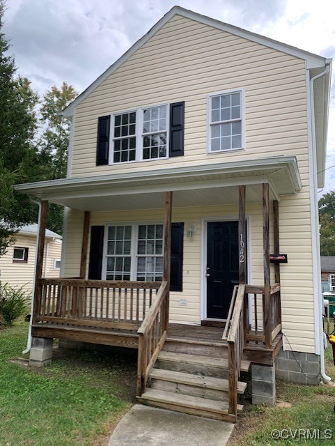 a view of a house with a deck and a yard