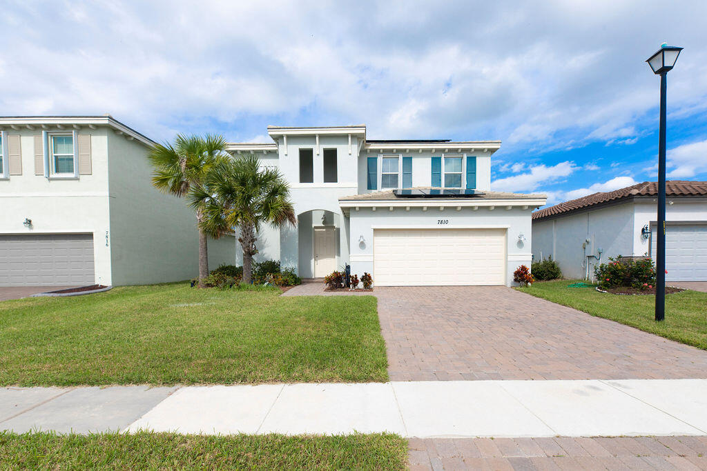 a front view of a house with a yard and garage