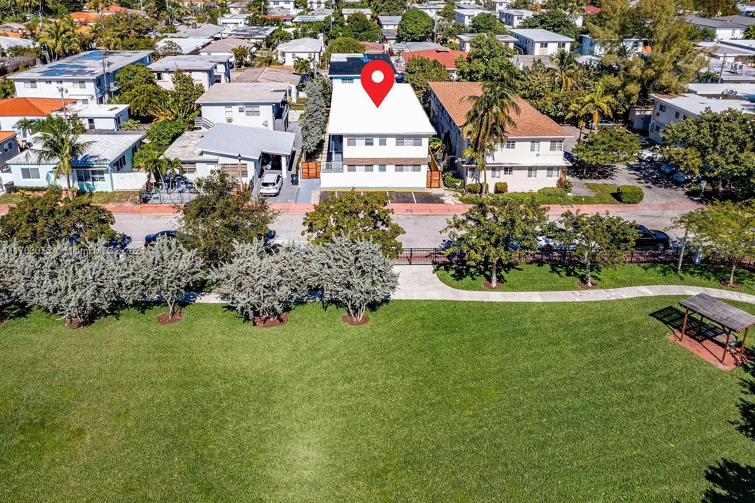 an aerial view of residential house with outdoor space and trees all around