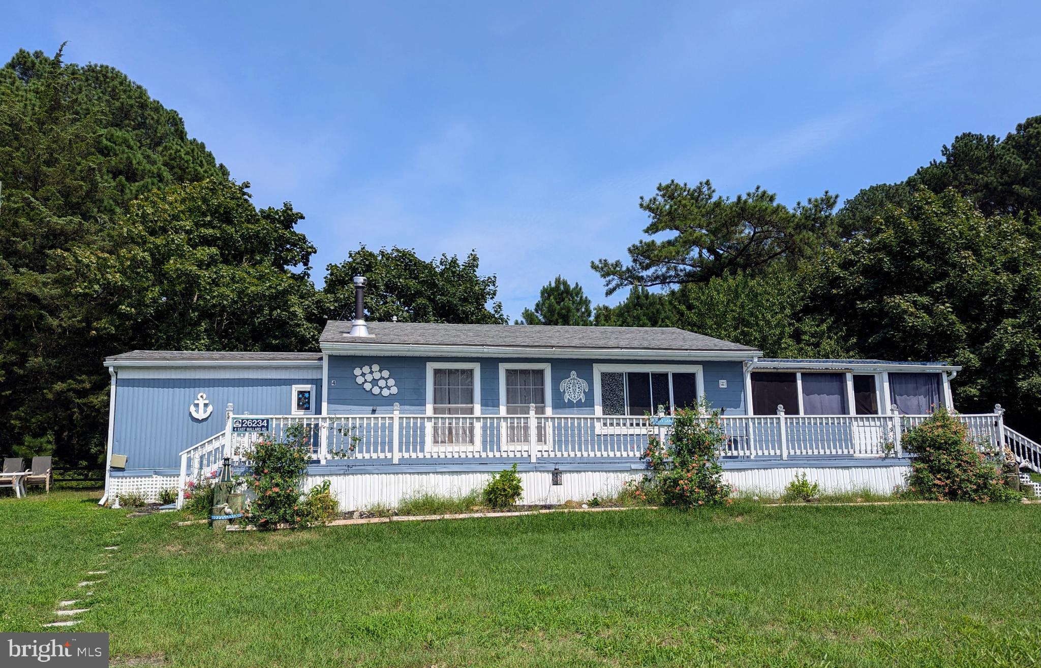 a view of a house with a yard deck and a large tree