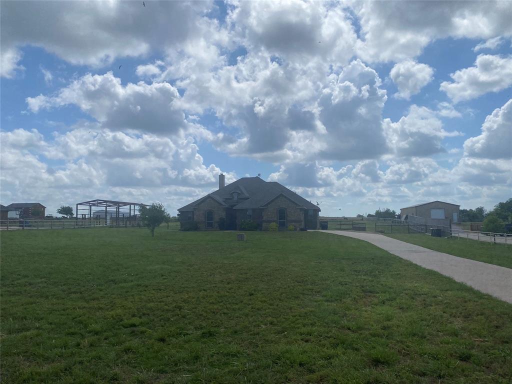 a view of a big yard with a house in the background