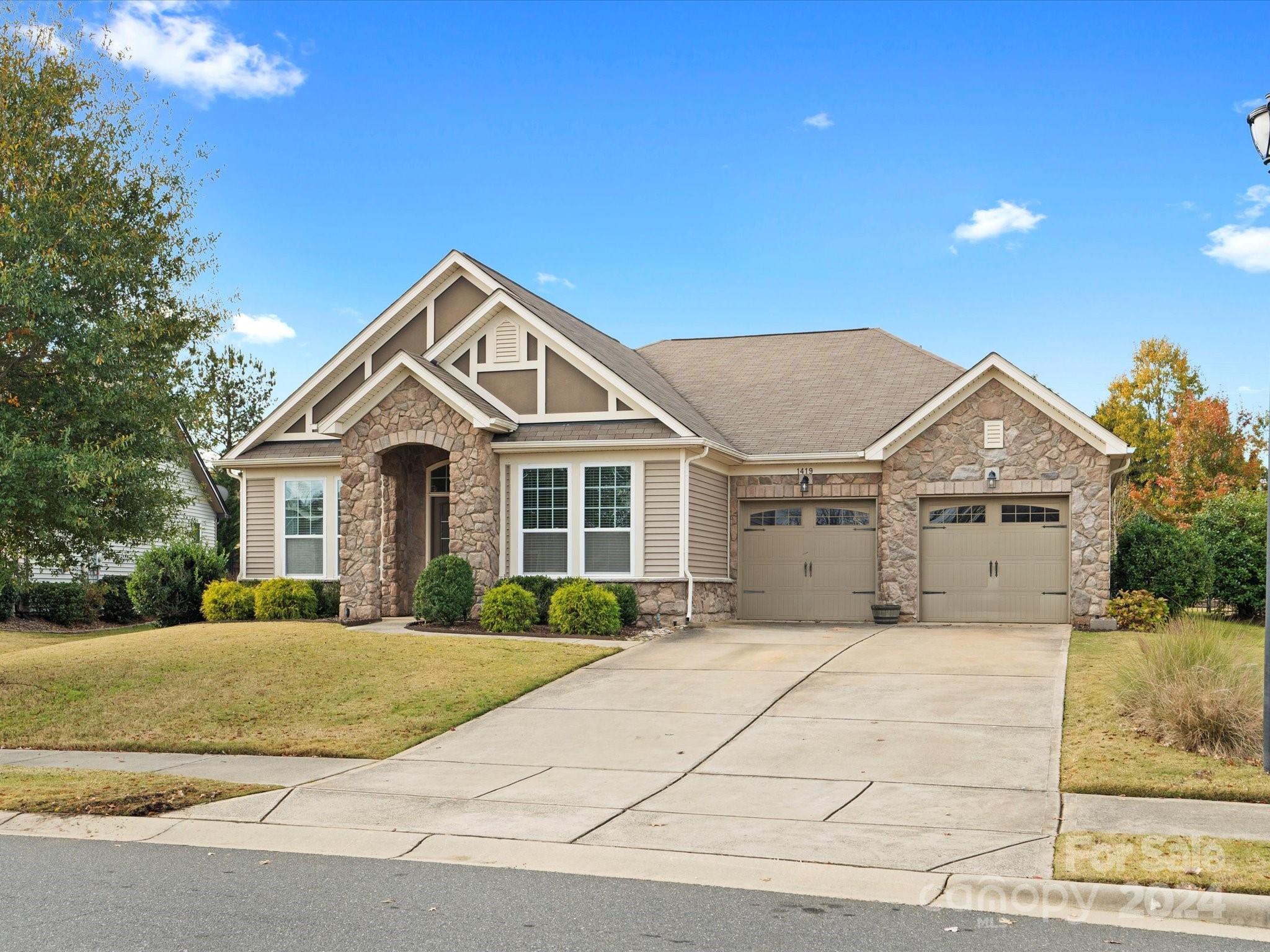 a front view of a house with a yard and garage