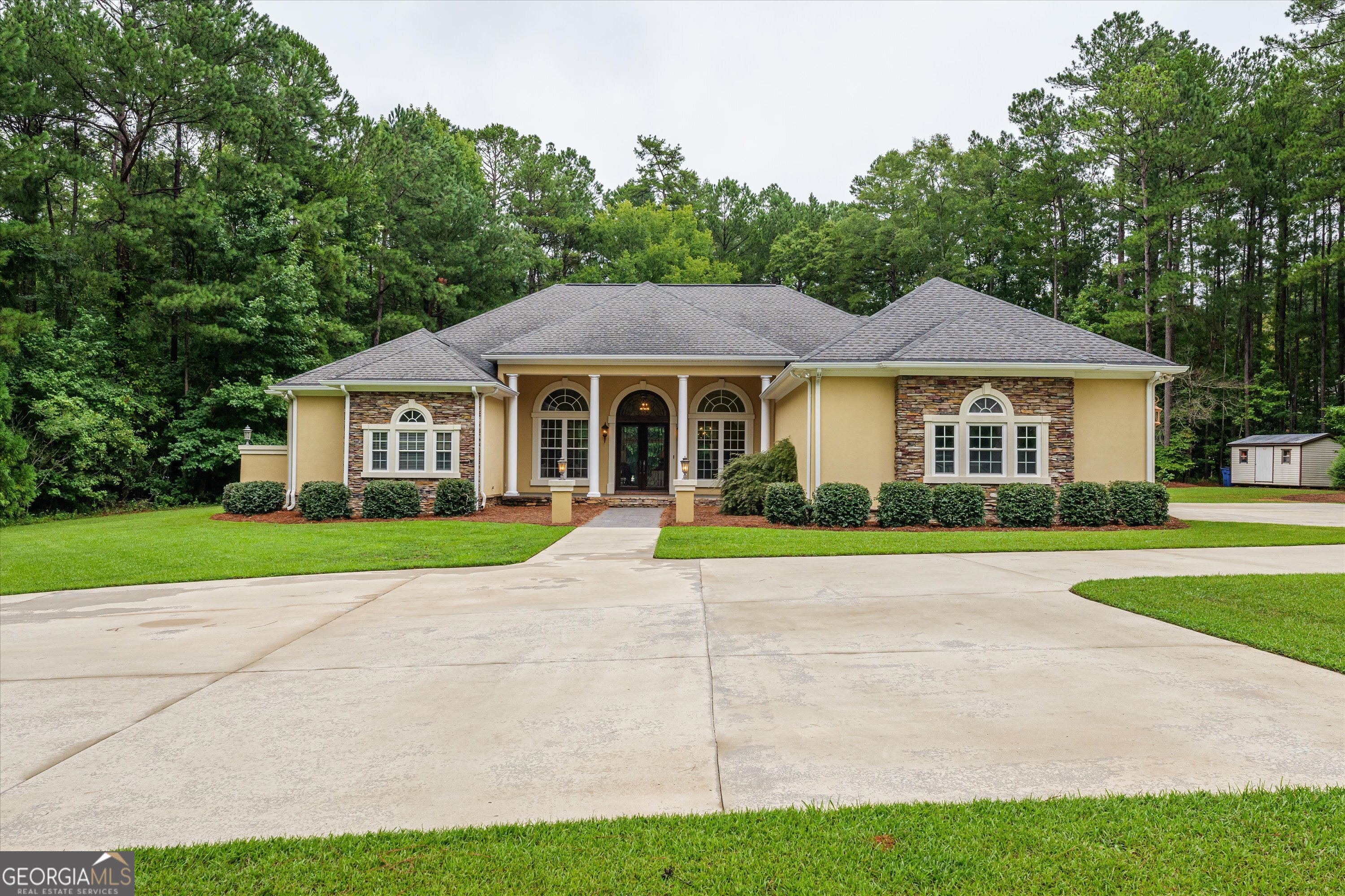 a view of a house with a yard and large trees