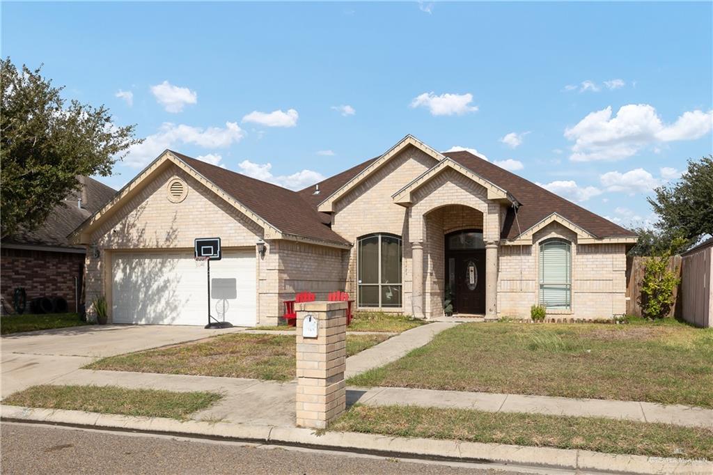 View of front facade featuring a garage and a front yard