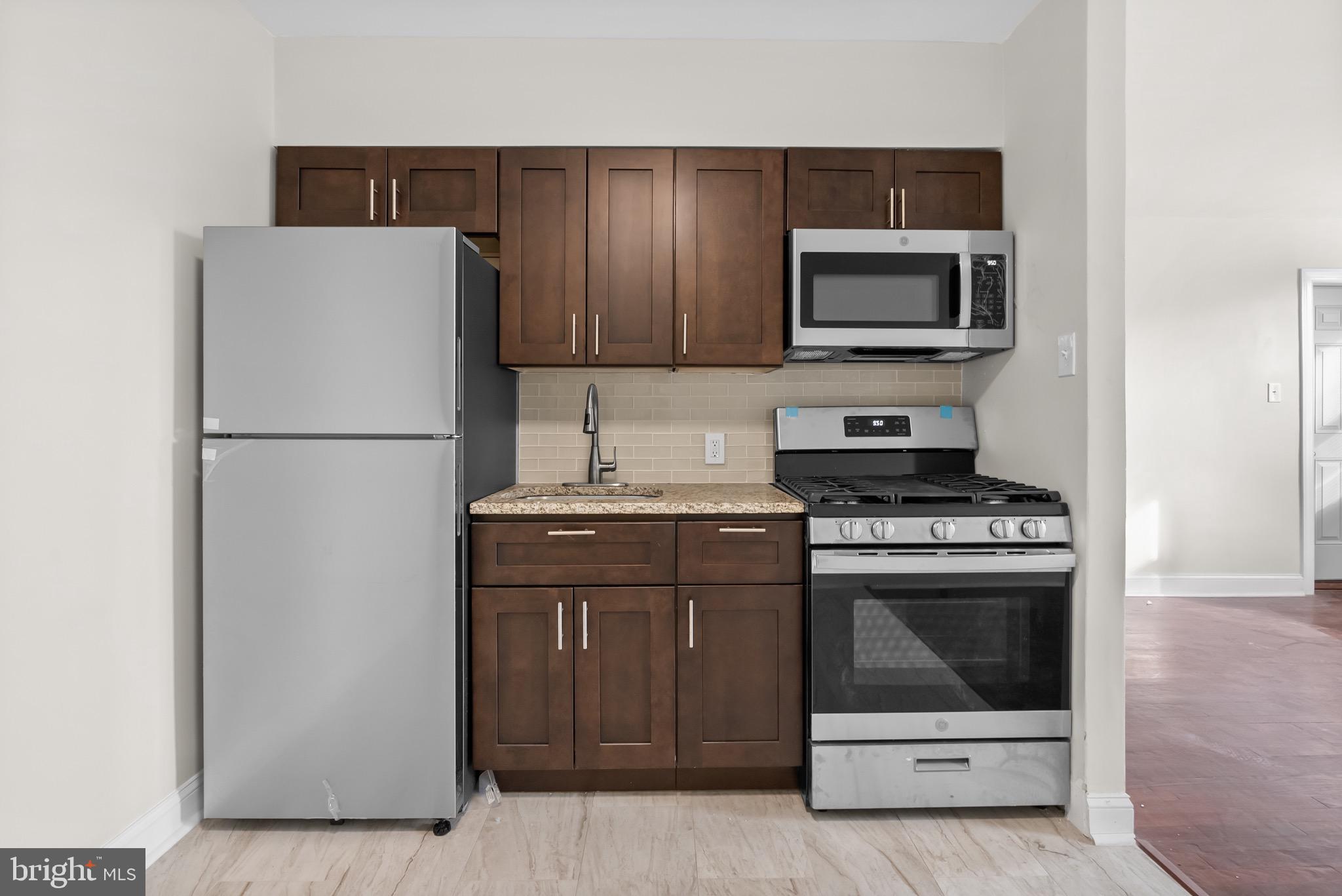 a kitchen with a refrigerator stove and microwave