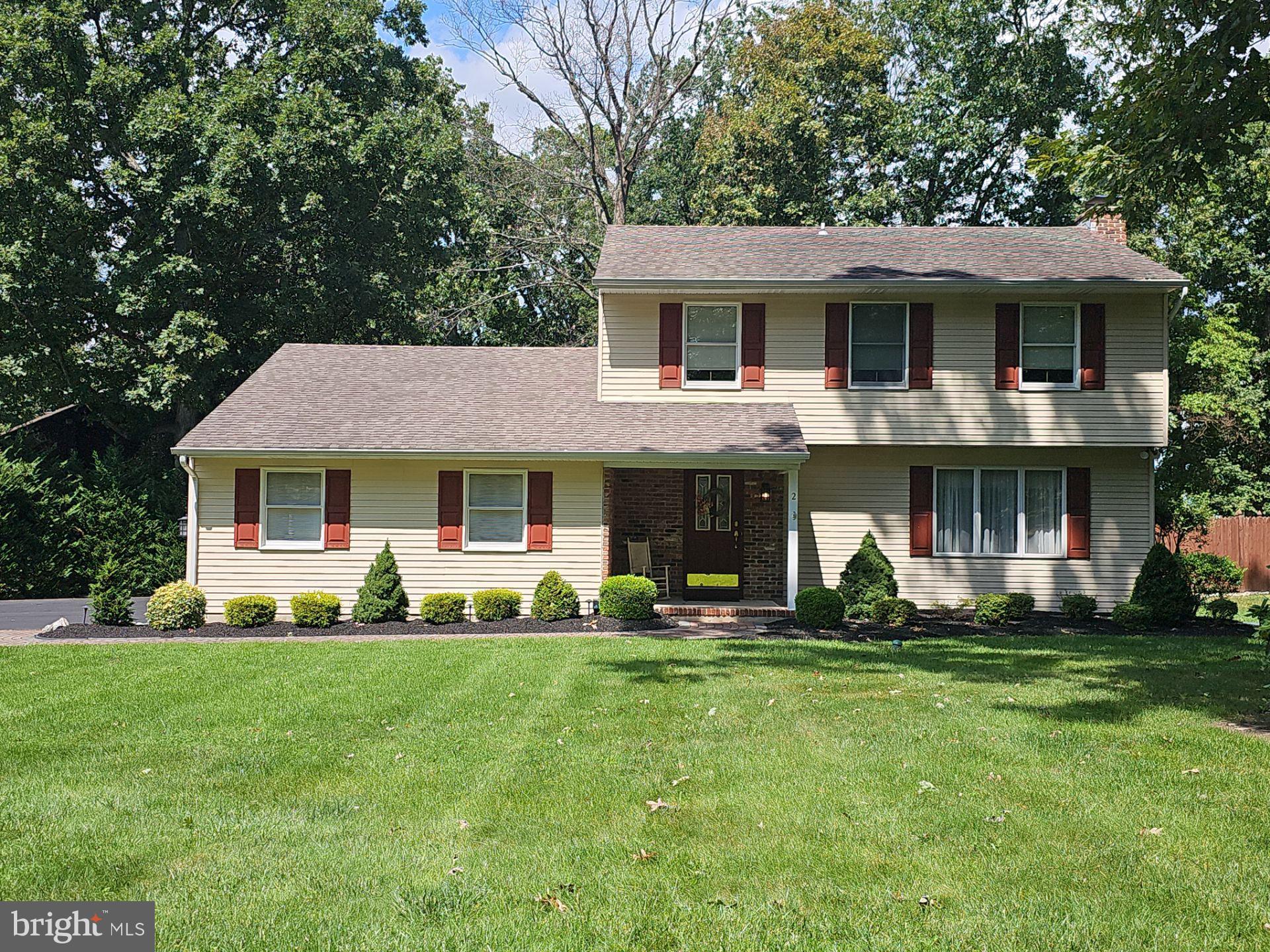 a front view of a house with a yard and trees