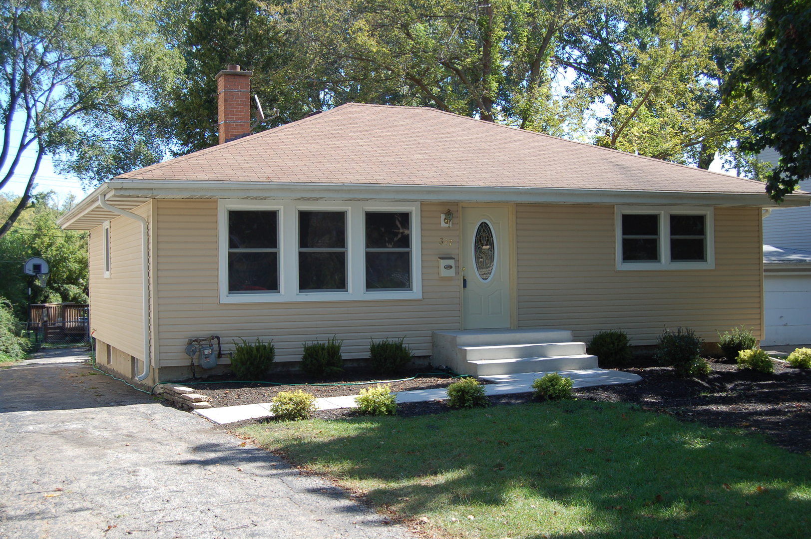 a front view of a house with a garden and yard