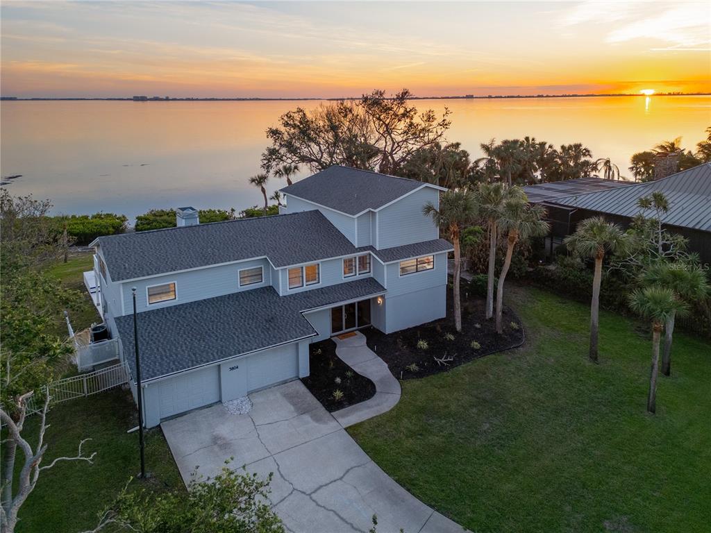 aerial view of a house with a garden and lake view