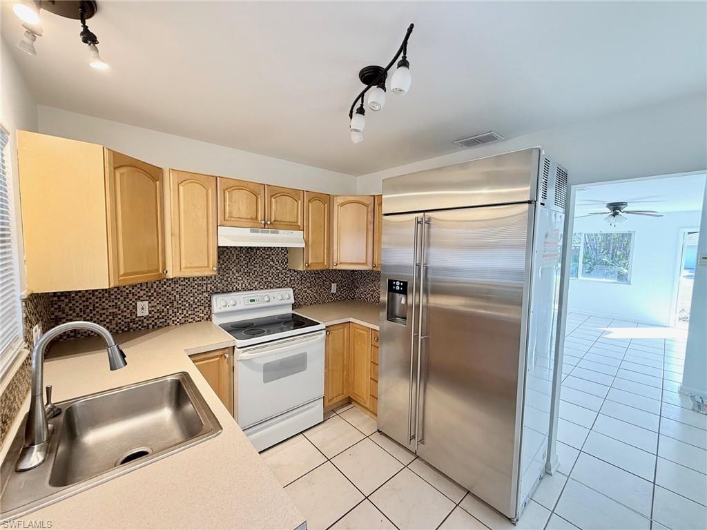 a kitchen with a refrigerator a sink and cabinets