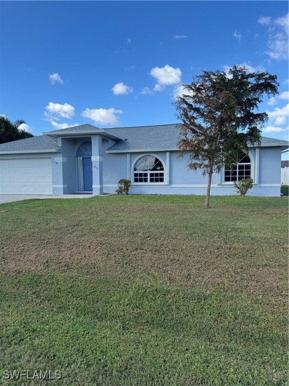 a view of a house with a yard and a large tree