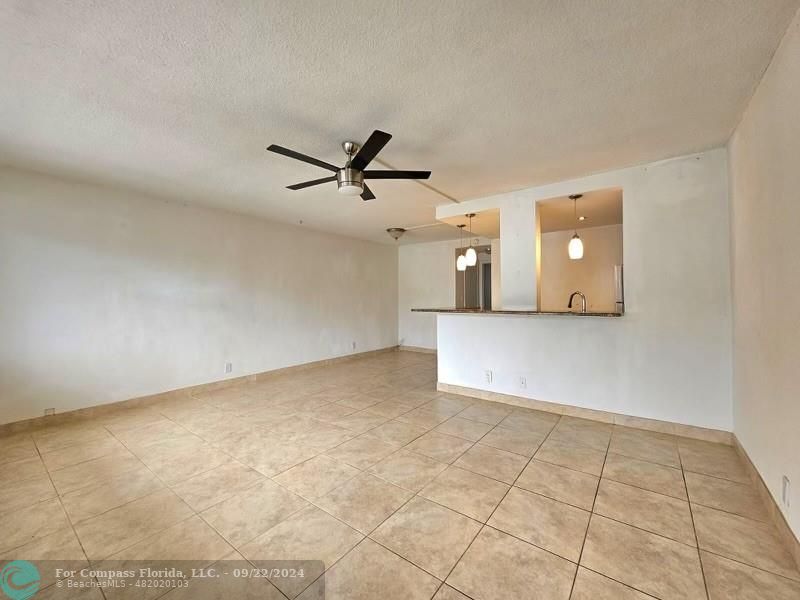 an empty room with a ceiling fan and windows