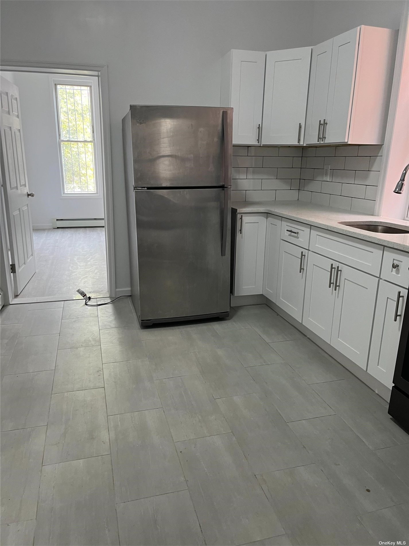 a kitchen with a refrigerator sink and cabinets