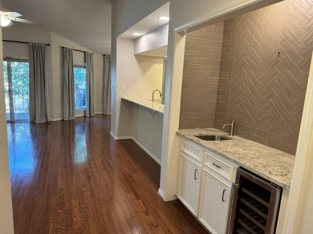 a kitchen with a sink and a wooden floor