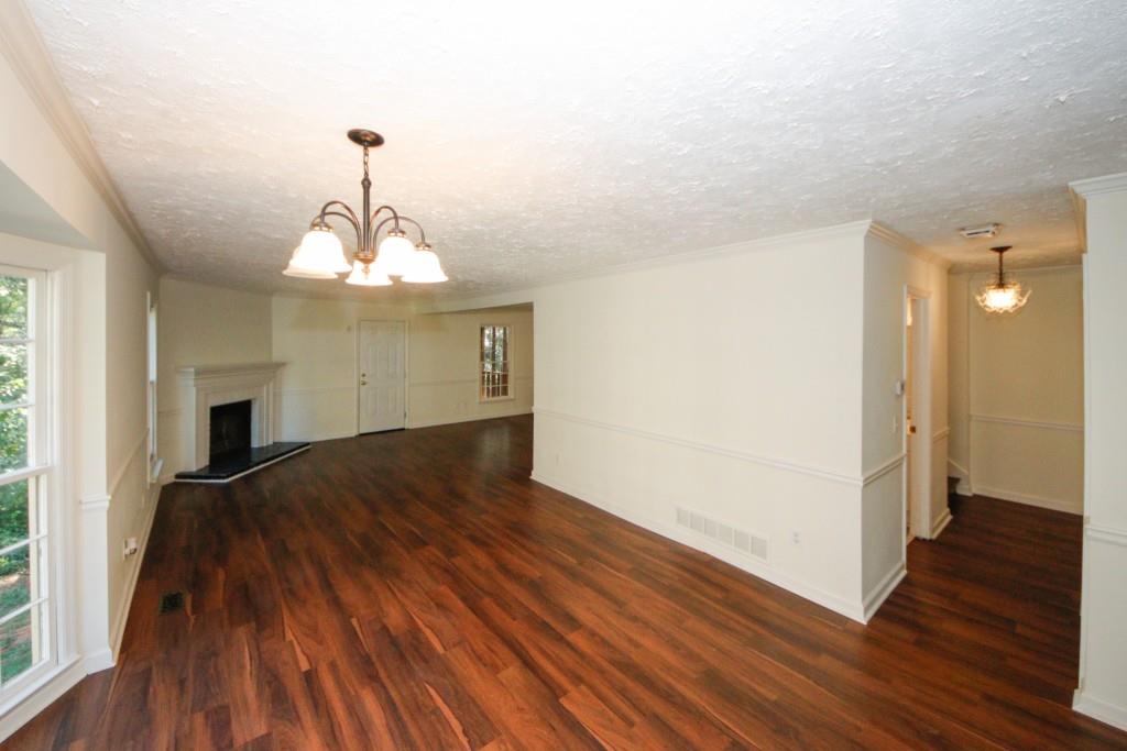 a view of a livingroom with wooden floor and staircase