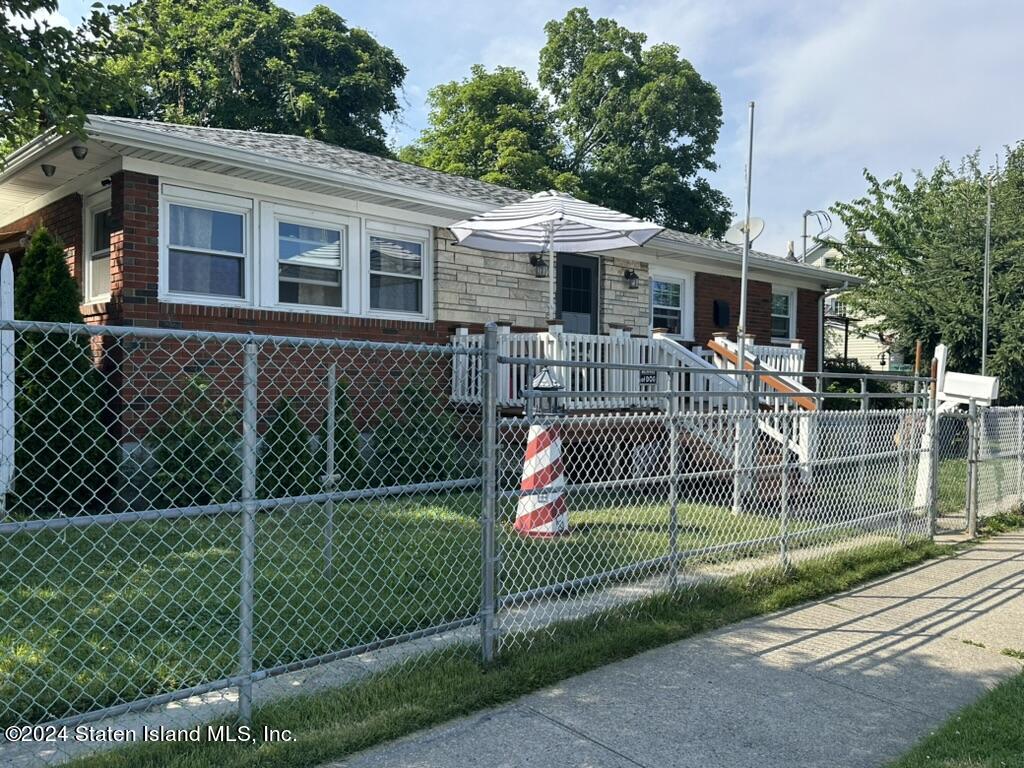 a view of a house with a small yard and wooden fence