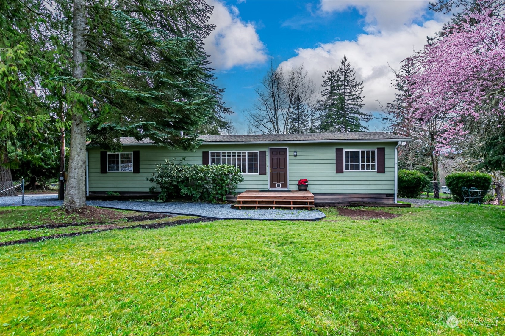 a front view of a house with a yard and trees