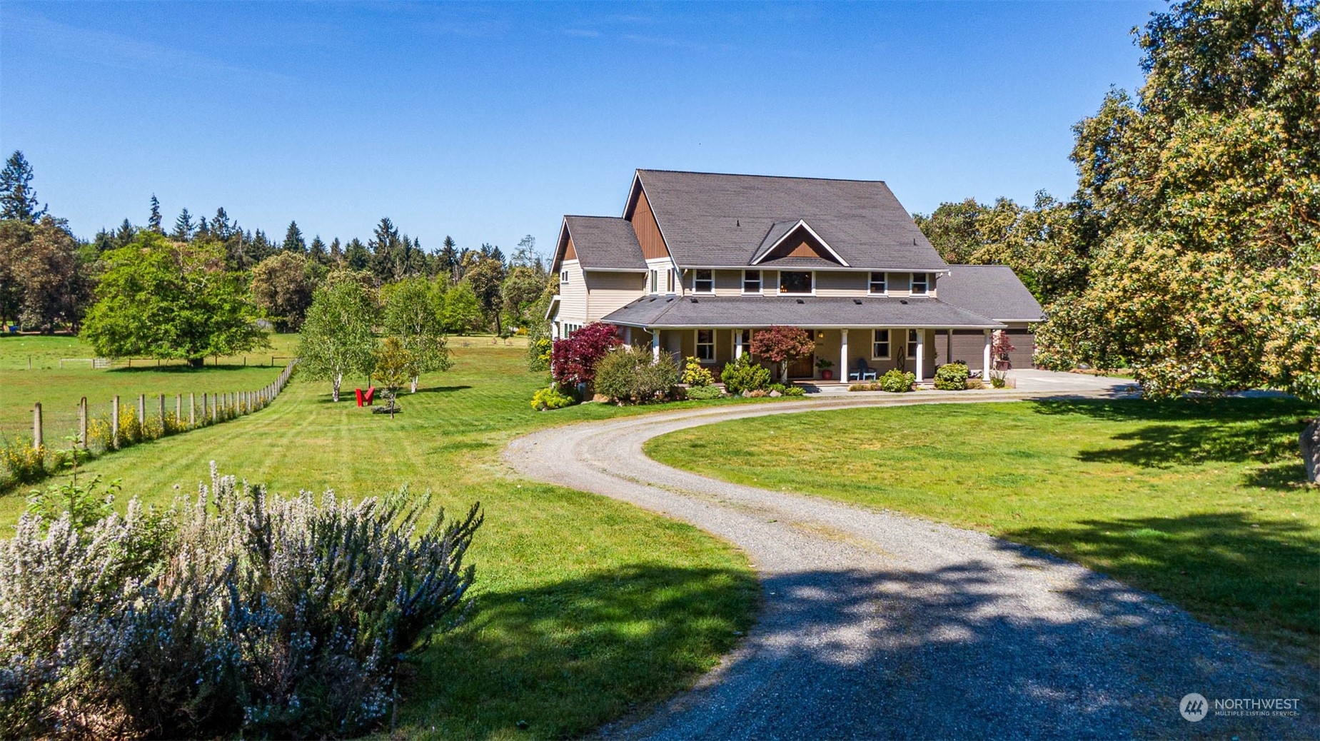 a view of a house with big yard and large trees