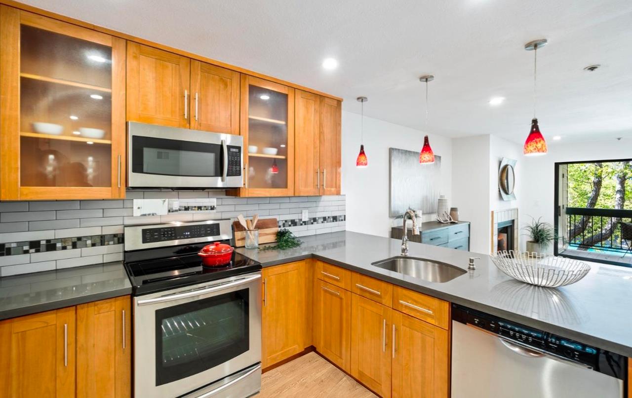 a kitchen with stainless steel appliances granite countertop a sink stove and cabinets