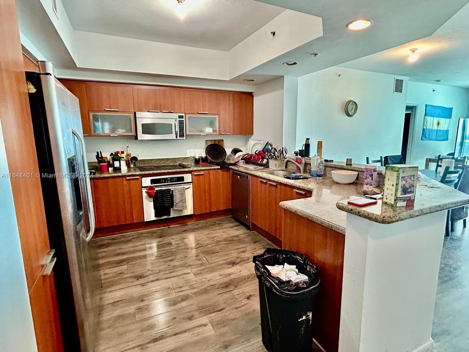 a kitchen with stainless steel appliances granite countertop a sink a stove and refrigerator