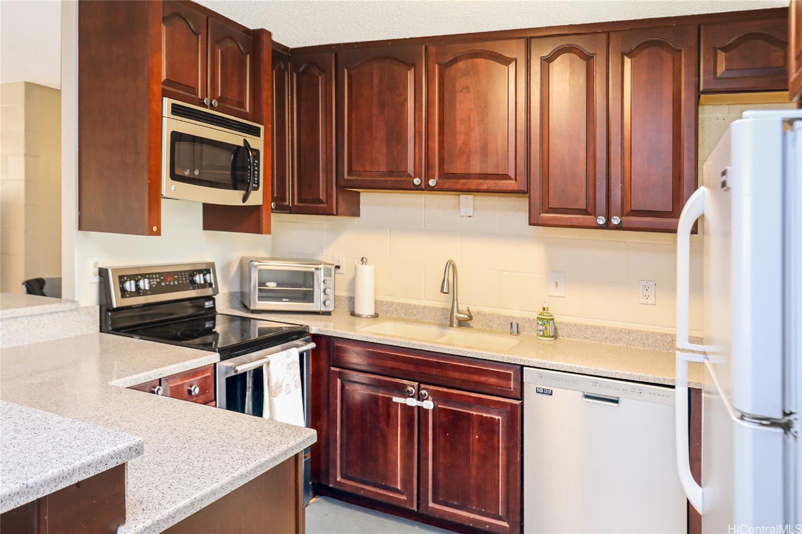 a kitchen with stainless steel appliances granite countertop a sink stove microwave and refrigerator