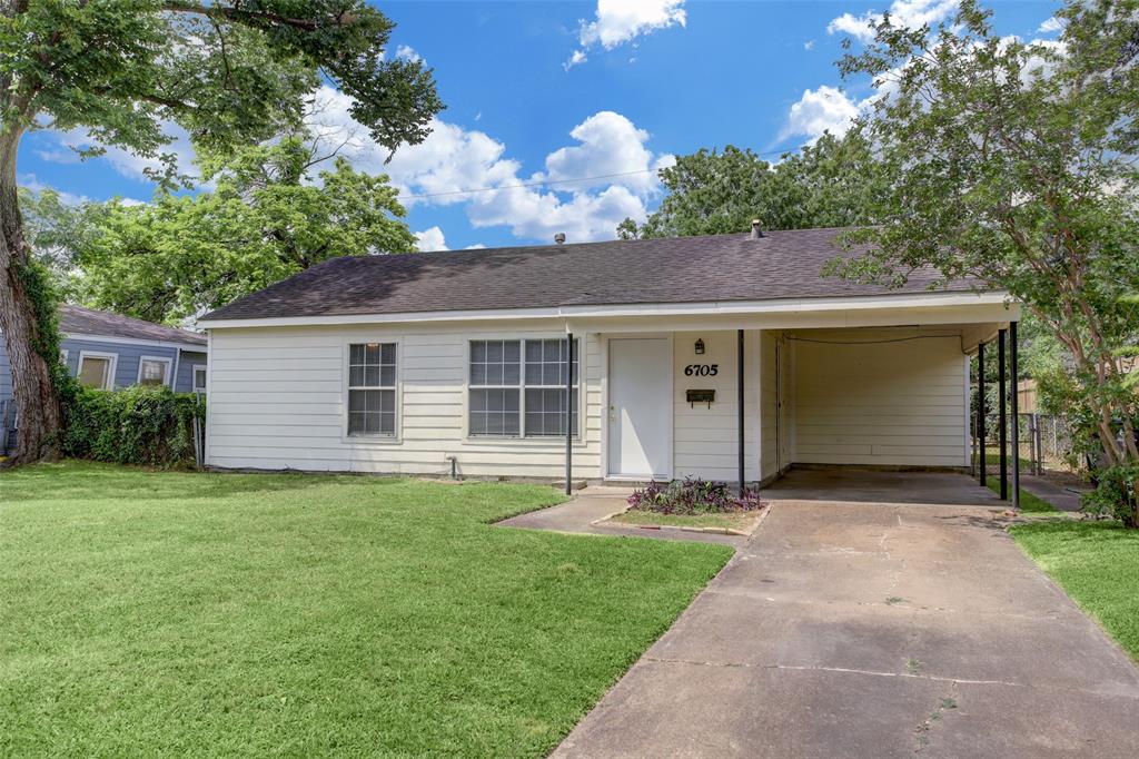 a front view of a house with a garden and yard