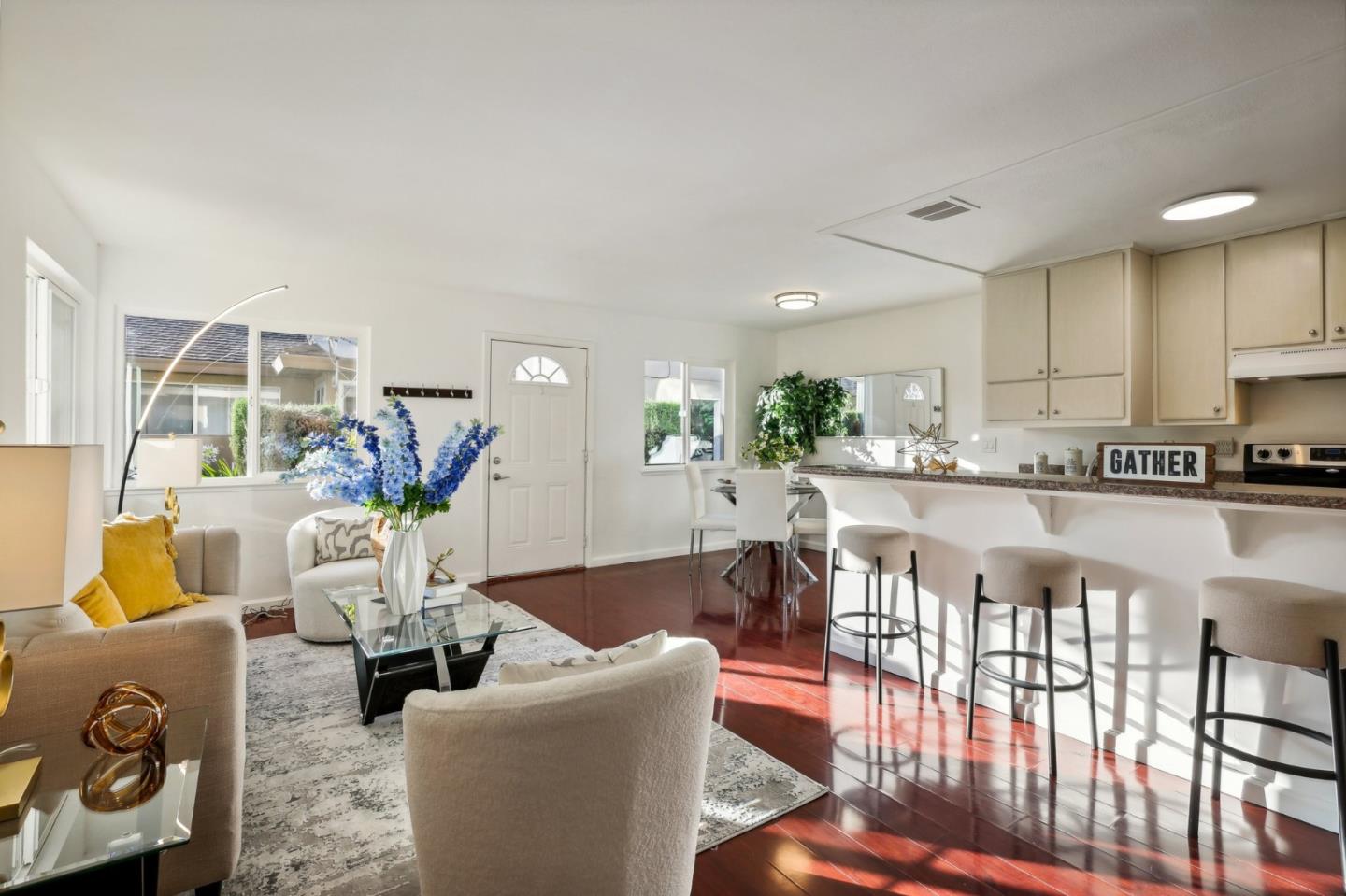 a living room with furniture and a dining table with kitchen view