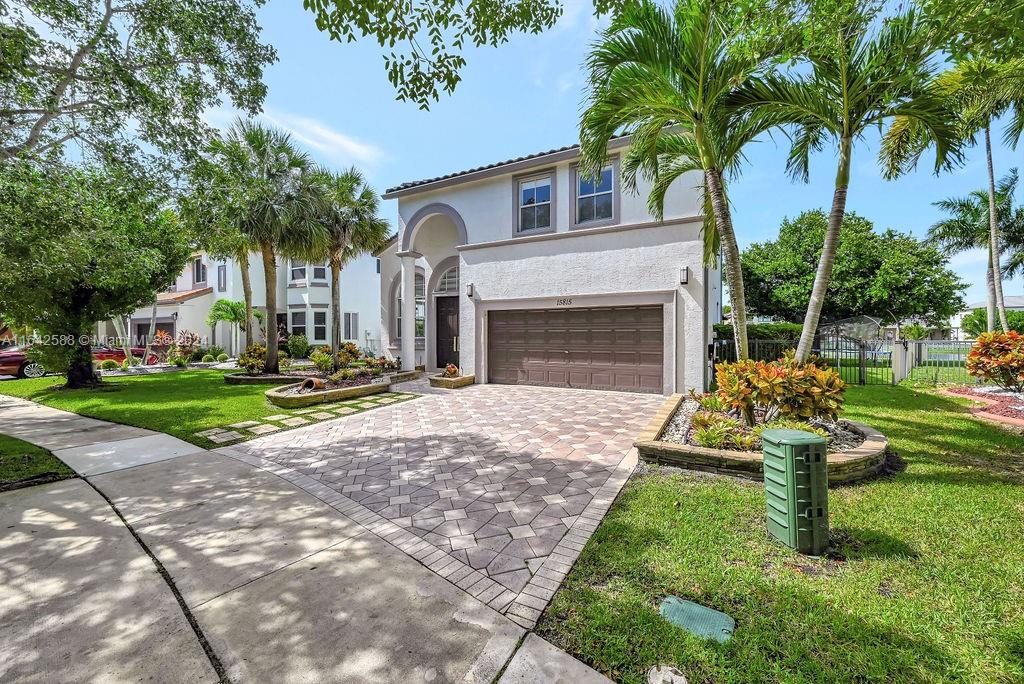 a view of a house with a yard and palm trees