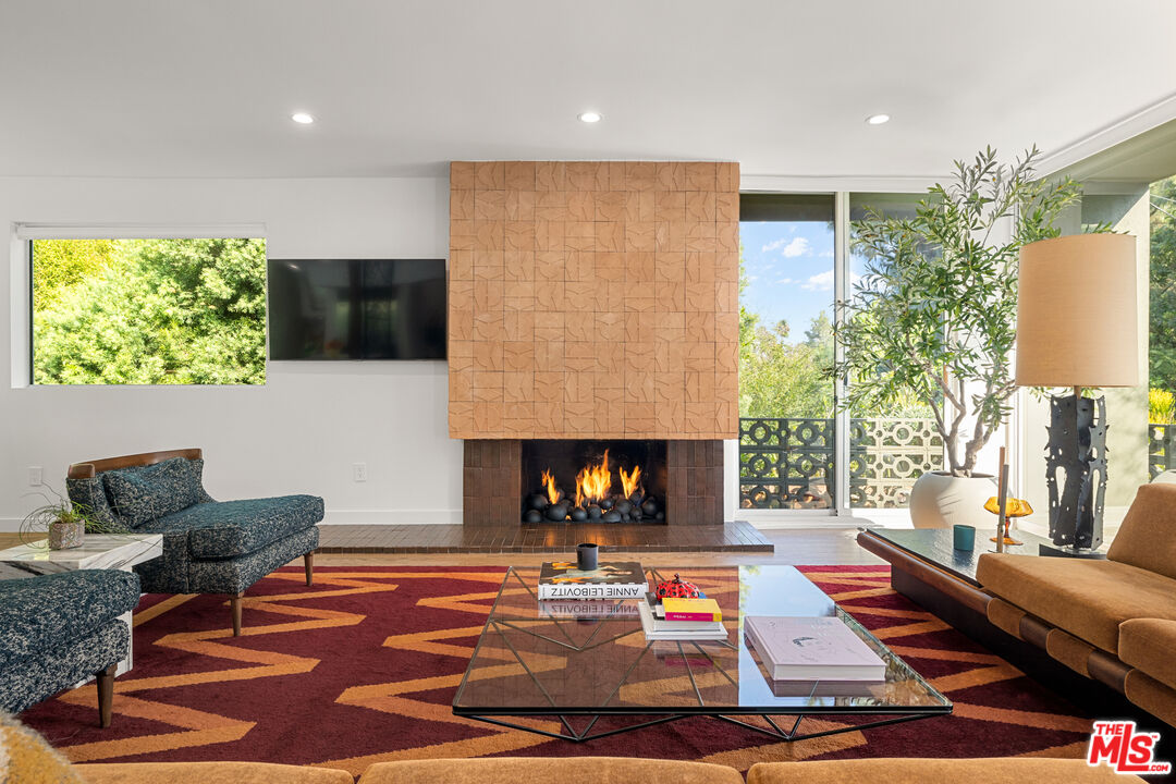 a living room with furniture a flat screen tv and a fireplace