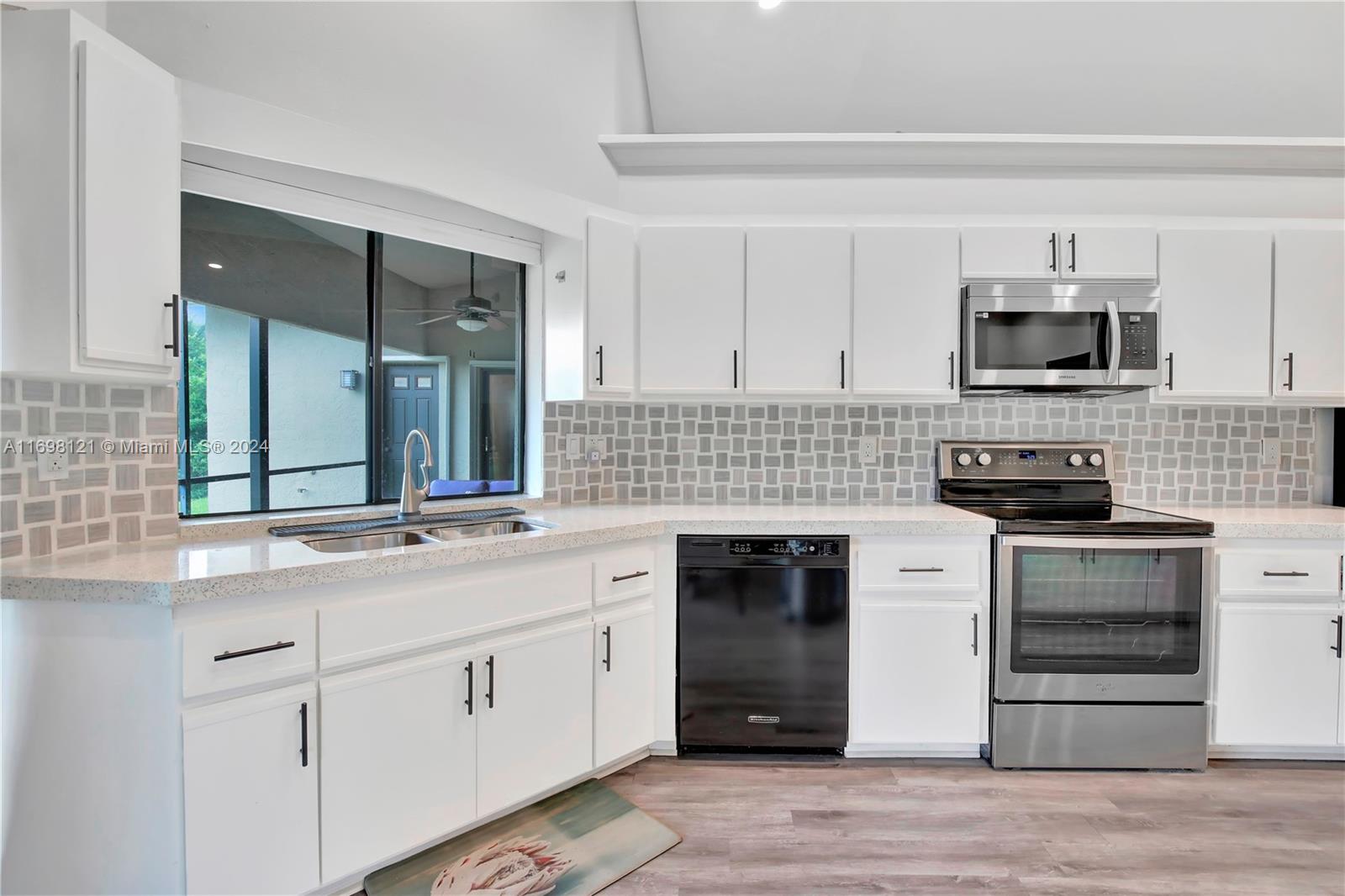 a kitchen with stainless steel appliances white cabinets and a stove top oven