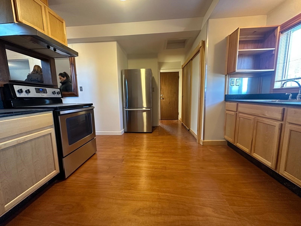 a kitchen with stainless steel appliances granite countertop a stove a sink and a refrigerator