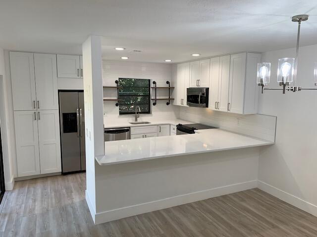 a kitchen with stainless steel appliances a refrigerator sink and microwave