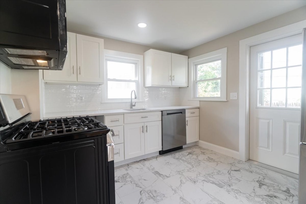 a kitchen with a stove a sink and a window