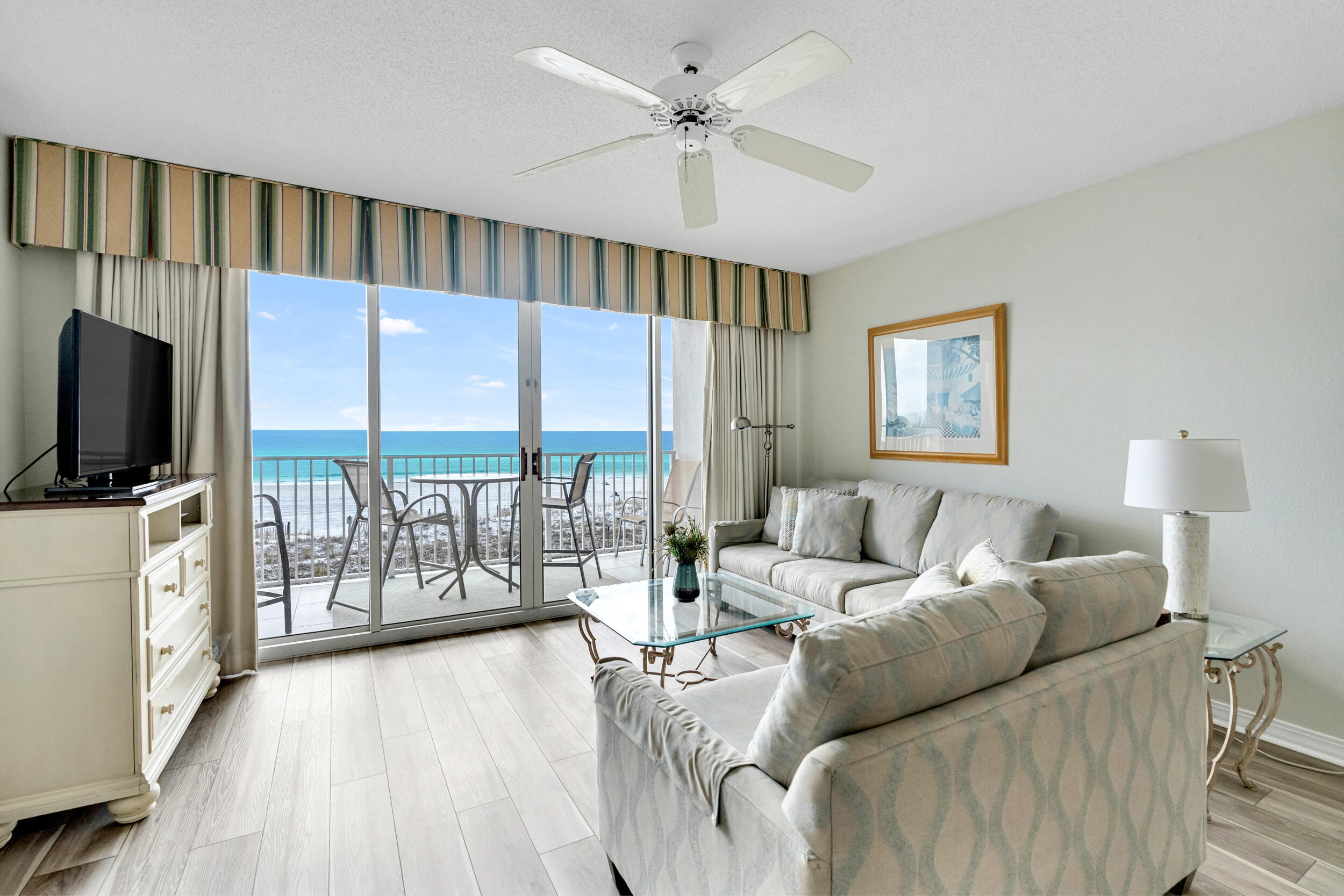 a living room with furniture a flat screen tv and a large window