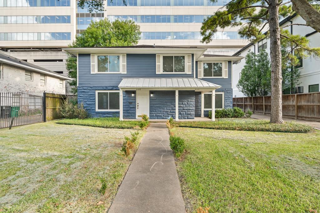 a front view of a house with yard and green space