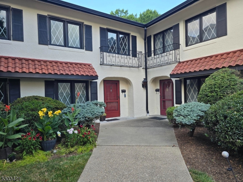 a front view of a brick house with potted plants