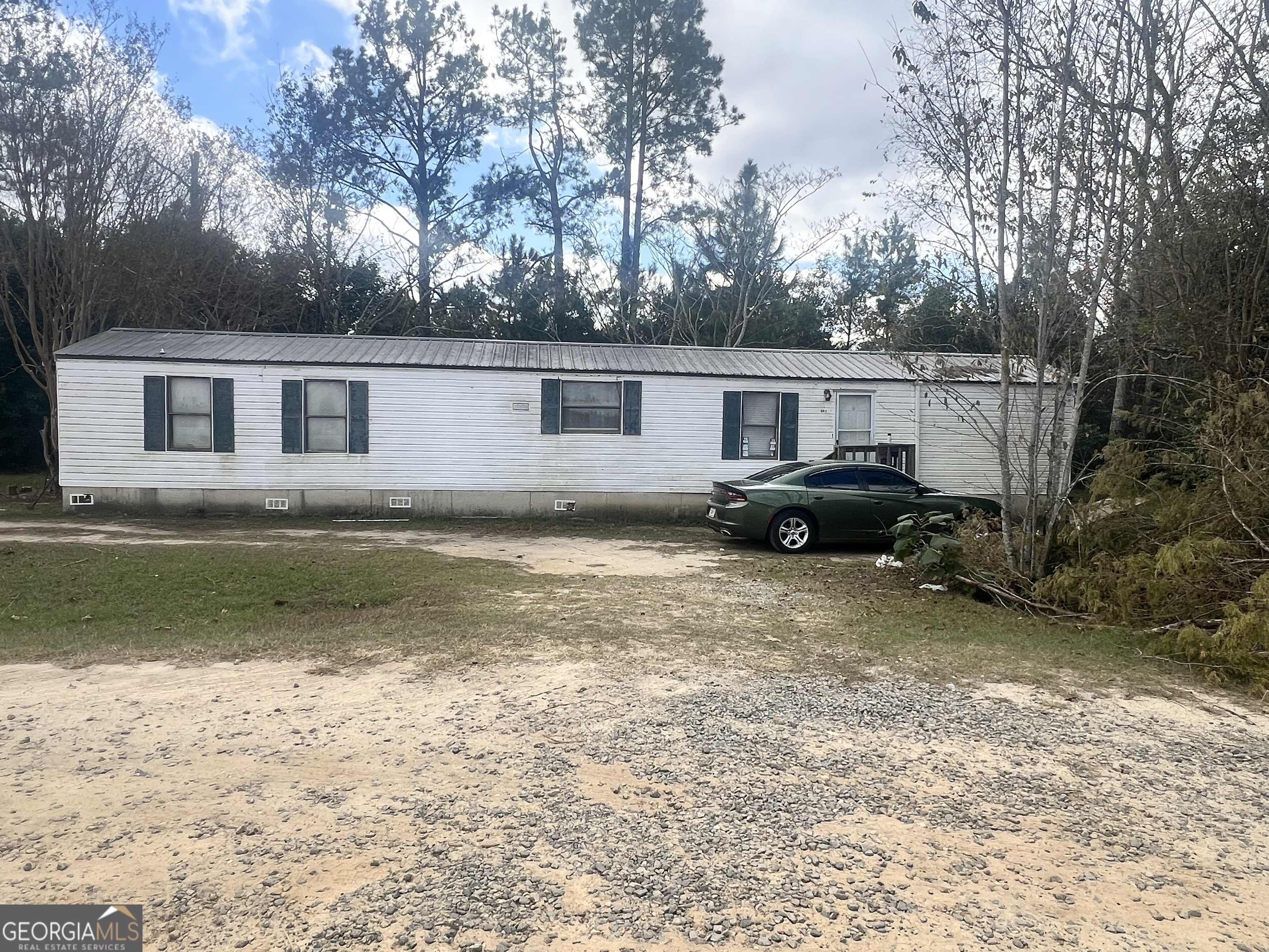 a view of a house with backyard and trees