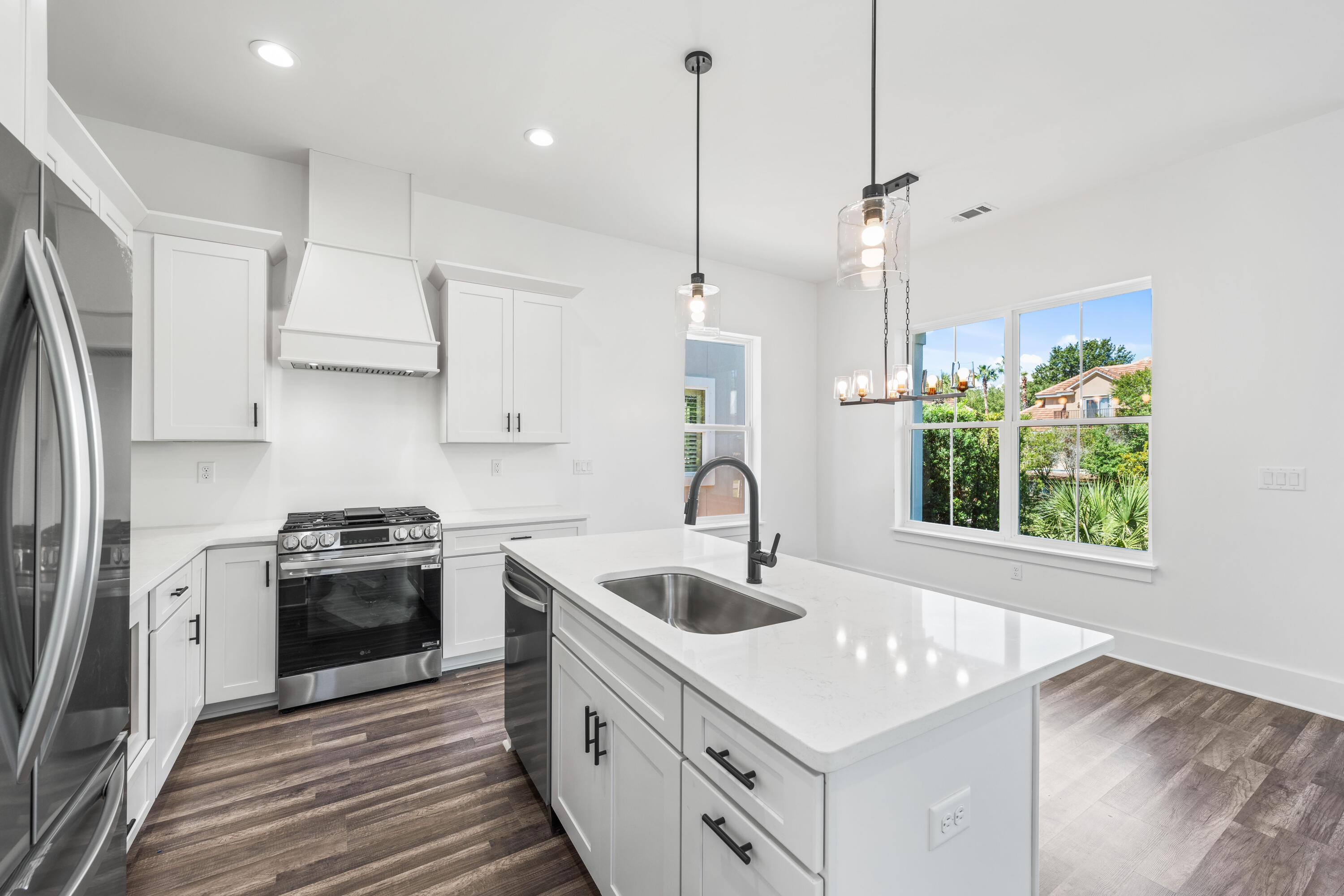 a kitchen with a sink a stove a refrigerator and a window