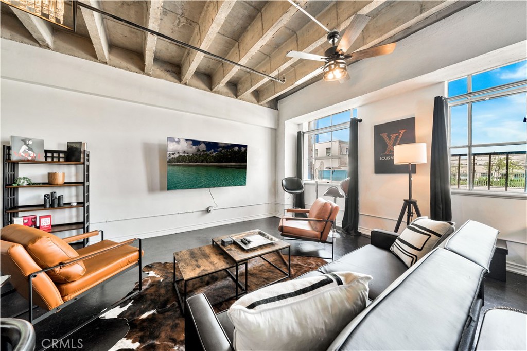 a living room with furniture a flat screen tv and a floor to ceiling window