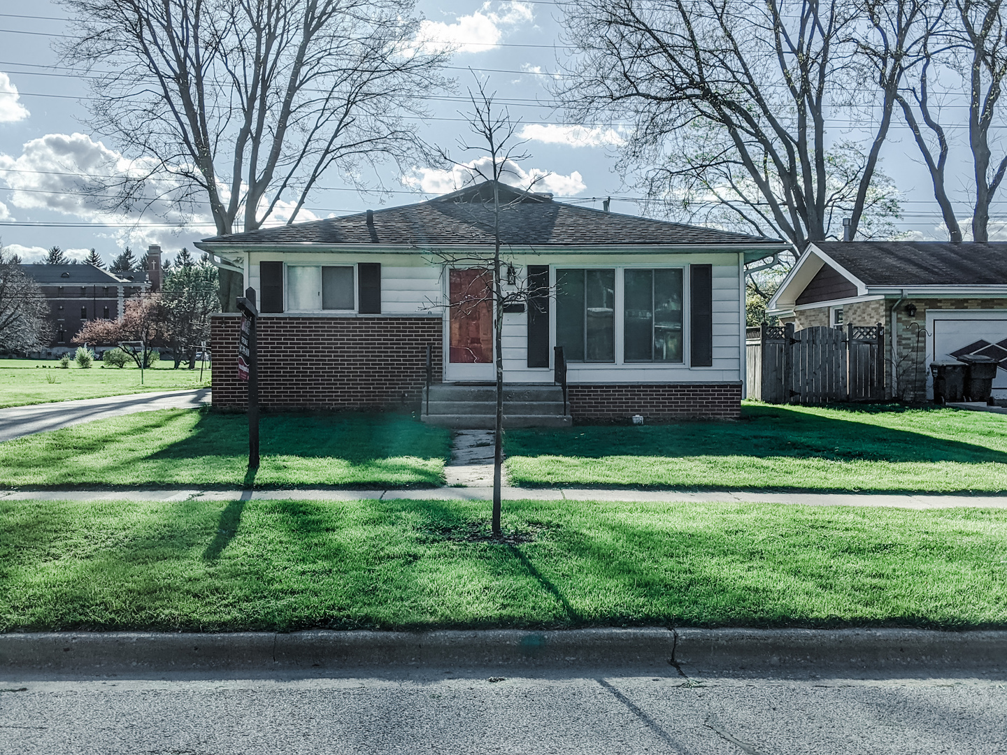 a view of a house with a yard and a large tree