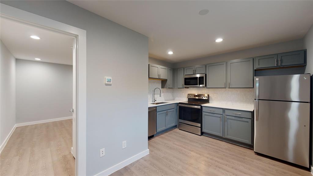 a kitchen with stainless steel appliances granite countertop a refrigerator and a stove top oven